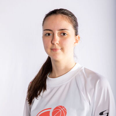 Eine junge Frau im TGL-Logo-Shirt posiert für ein Porträt, das den sportlichen Geist des Turnvereins Landshut zeigt.