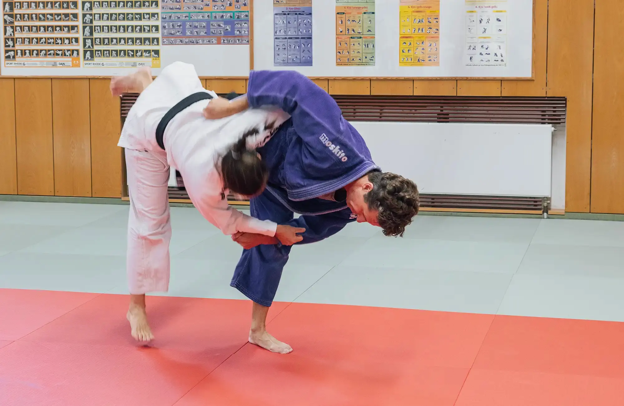 Zwei Judoka der Turngemeinde Landshut trainieren eine Wurftechnik auf der Matte im Verein.