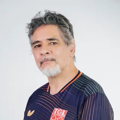 Ein Mann im TGL-Trikot steht mit einem Buch in der Hand und repräsentiert den Sportverein Turngemeinde Landshut.