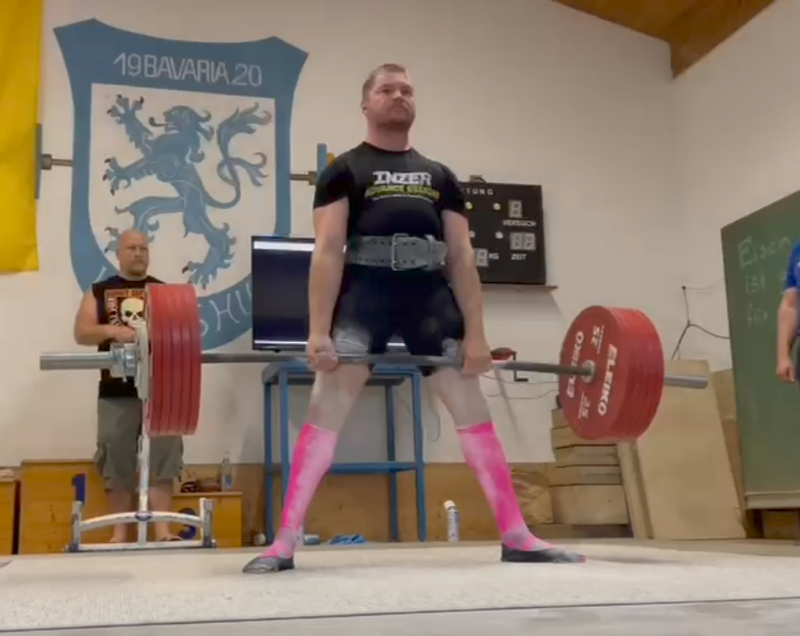 Ein Mann hebt schwere Gewichte in der Turnhalle der Turngemeinde Landshut während eines Wettkampfs.