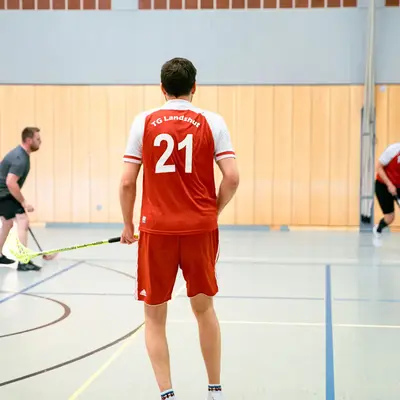 Ein Spieler der TG Landshut bereitet sich in der Sporthalle auf einen Floorballspielzug vor.