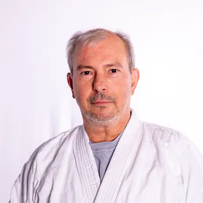 Ein Mann in einem weißen Kampfsportanzug repräsentiert die Turngemeinde Landshut mit entschlossenem Ausdruck.