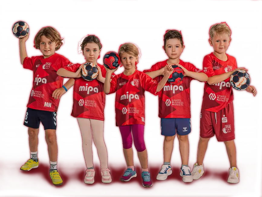 Eine fröhliche Handballmannschaft der Turngemeinde Landshut posiert in roten Trikots mit Bällen.