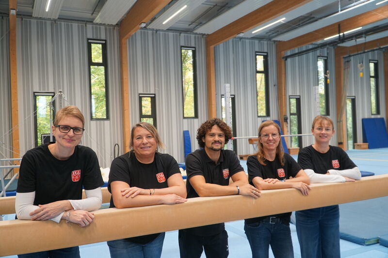 Fünf Übungsleiter in TGL-Shirts in der Turnhalle der TGL.