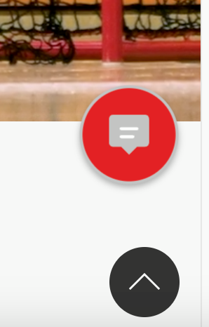 Ein roter Button mit einem Chat-Symbol ist über einem Sporthallenboden der Turngemeinde Landshut zu sehen.
