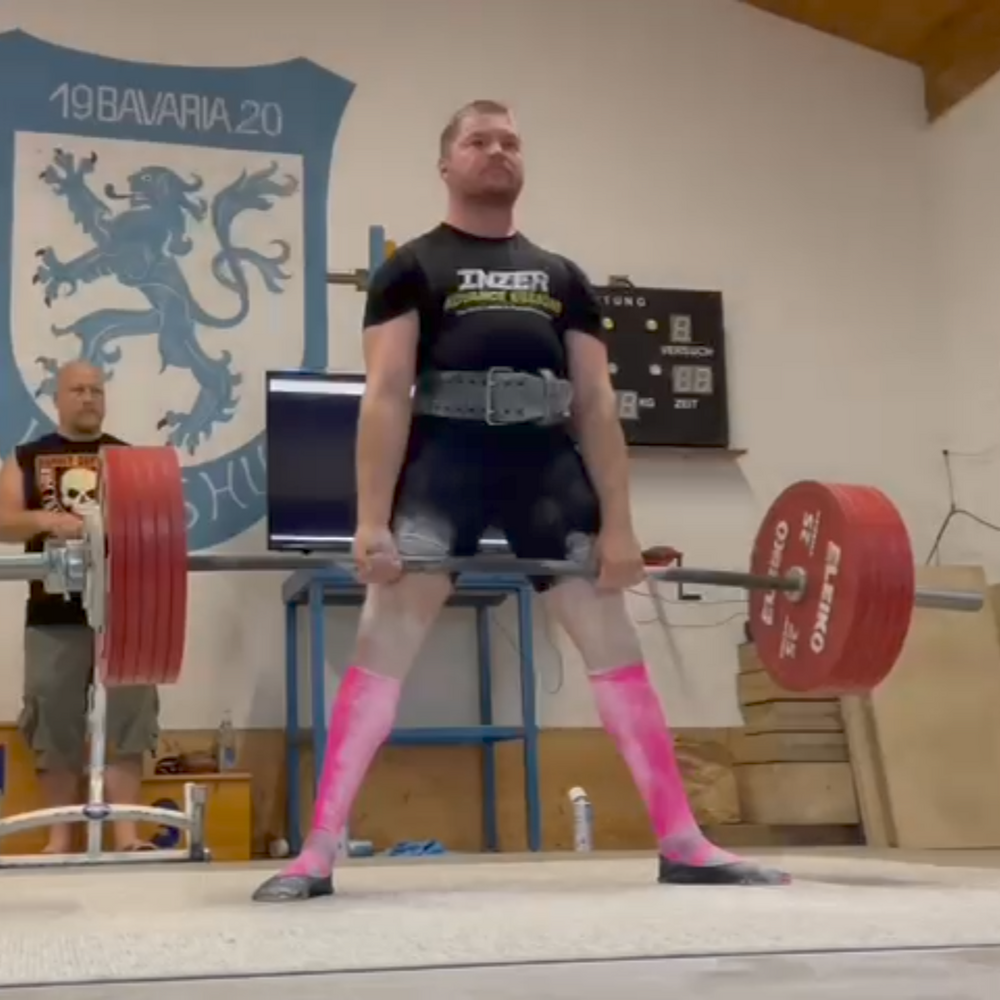 Ein Mann hebt schwere Gewichte in der Turnhalle der Turngemeinde Landshut während eines Wettkampfs.