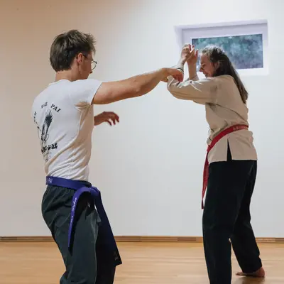 Ein Mann und eine Frau üben Kampfkunst in einem Raum der Turngemeinde Landshut.