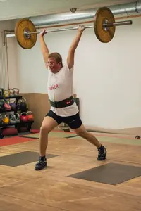 Ein Gewichtheber der Turngemeinde Landshut stemmt konzentriert eine Langhantel im Trainingsraum des Vereins.