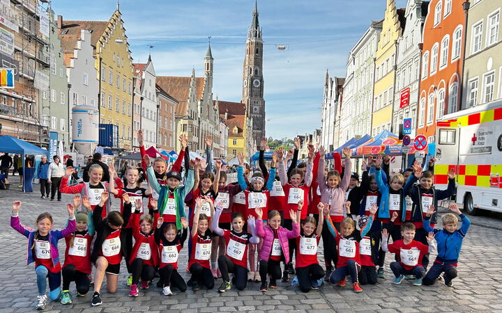 Kinder der Turngemeinde posieren fröhlich bei einem Leichtathletik-Event in der Altstadt von Landshut.