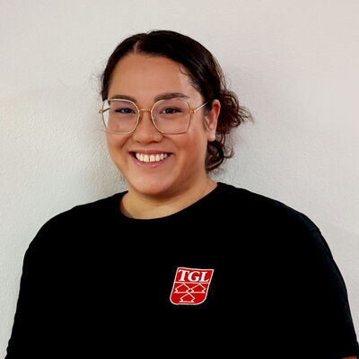 Eine Tänzerin in einem schwarzen TGL-Shirt lächelt stolz und repräsentiert den Sportverein in Landshut.