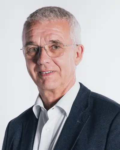 Schatzmeister Georg Schächinger in Anzug und Brille repräsentiert die Turngemeinde Landshut, ein bekannter Sportverein.