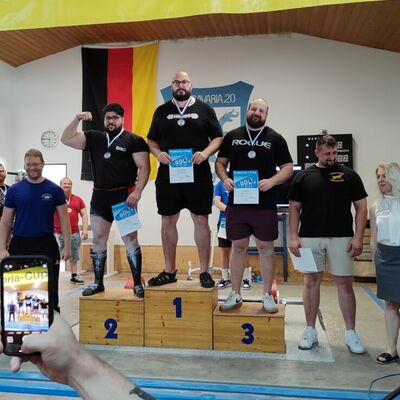 Drei Athleten stehen stolz auf dem Siegerpodest beim Maria-Cup, organisiert von einem Sportverein in Landshut.