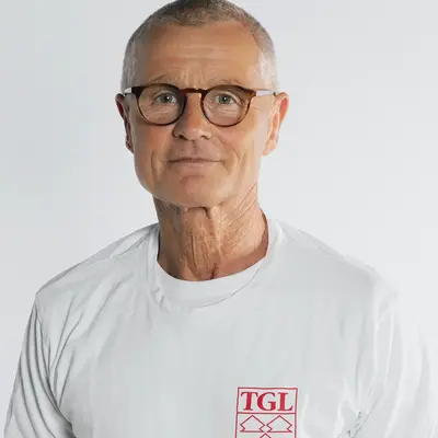 Ein Trainer der Turngemeinde Landshut trägt ein T-Shirt mit dem TGL-Logo in einem Sportverein.