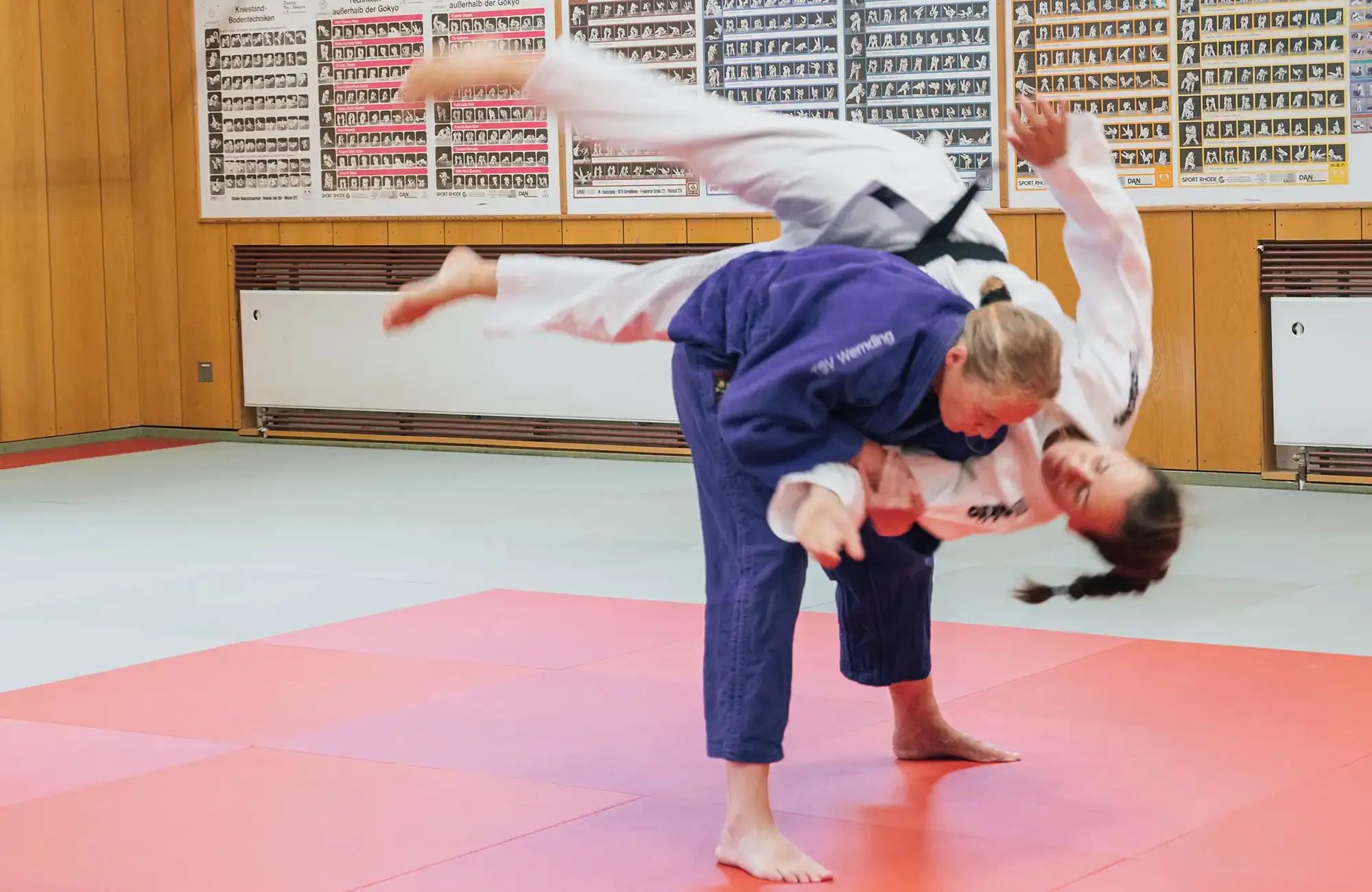 Zwei Judokas der Turngemeinde Landshut trainieren eine Wurftechnik auf der Matte im Verein.