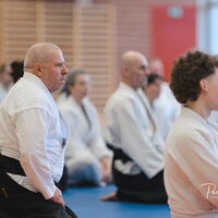 Aikidokas lauschen, sitzend im Seiza, aufmerksam den Weisheite von Christian Tissier
