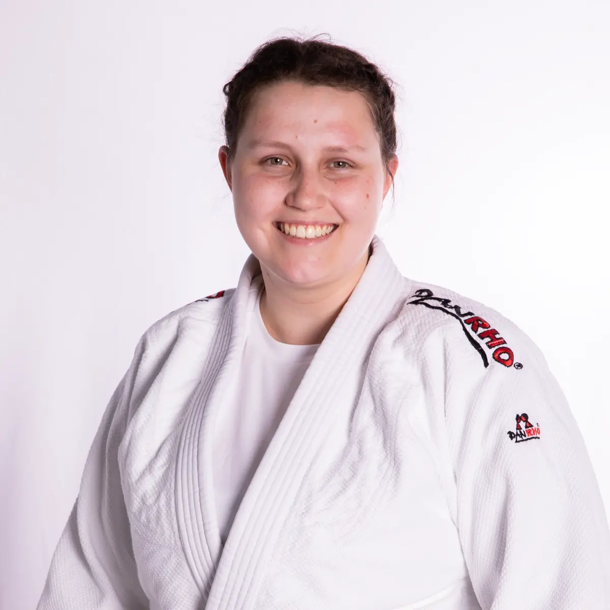 Eine lächelnde Person im Judogi repräsentiert stolz den Sportverein Turngemeinde Landshut.