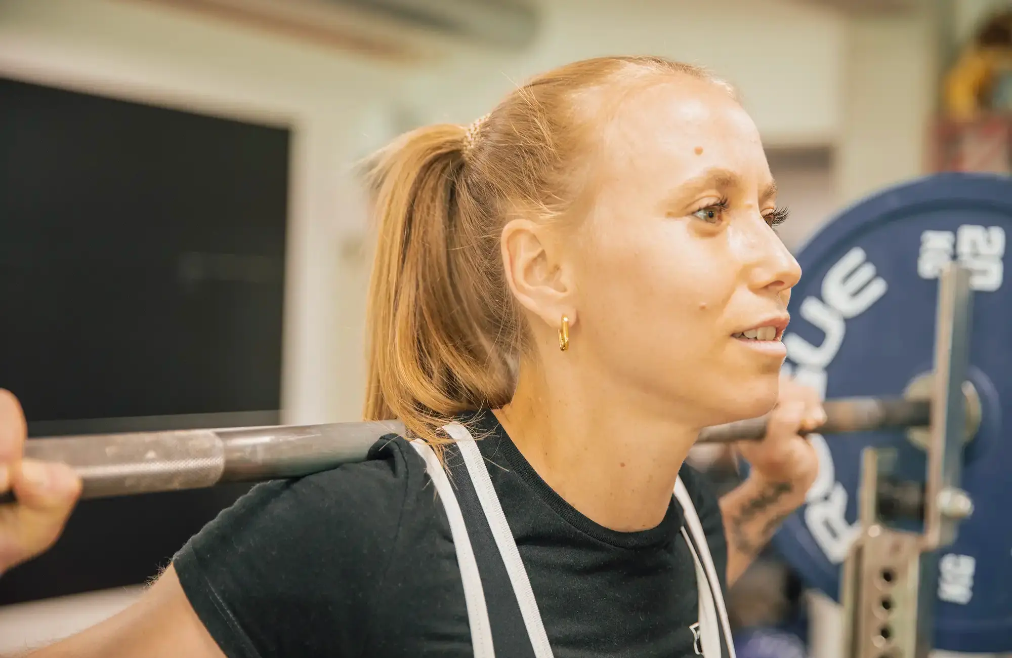 Eine Frau hebt konzentriert Gewichte im Fitnessstudio des Sportvereins Turngemeinde Landshut.